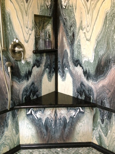 Marble shower walls with black granite trim.